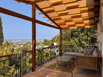 a patio with a bench and a table on a balcony at A historic STONE VILLA with private garden, terrace and private pool just for you in Kérynia