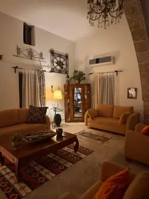 a living room with two couches and a coffee table at A historic STONE VILLA with private garden, terrace and private pool just for you in Kérynia