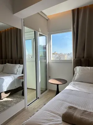a hotel room with two beds and a window at Aurora Downtown Living in Nicosia
