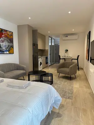 a bedroom with a bed and two chairs and a table at Aurora Downtown Living in Nicosia