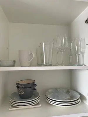 a shelf with plates and wine glasses on it at Aurora Downtown Living in Nicosia