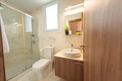 a bathroom with a toilet and a sink and a shower at Jupiter Villa in Voroklini