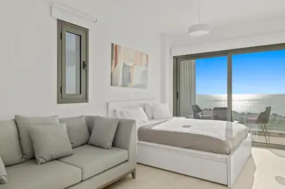 a white bedroom with a bed and a couch at Serenity Waves Villa 2 in Larnaka