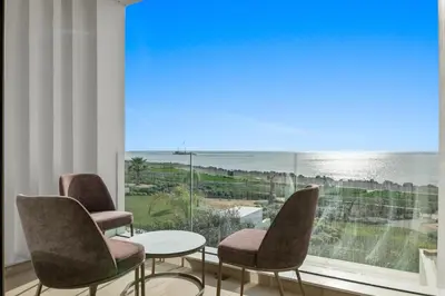 a room with two chairs and a table and a large window at Serenity Waves Villa 2 in Larnaka