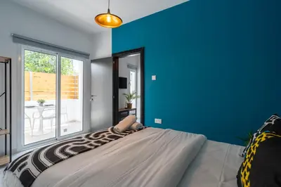 a bedroom with a large bed with a blue wall at The Pop Art Residences & Studios in Larnaca in Larnaka