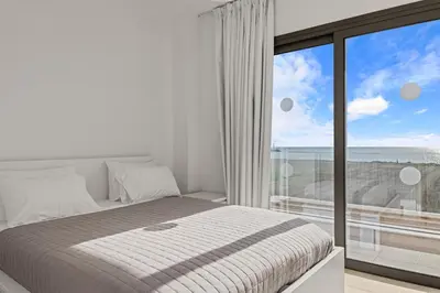a bedroom with a bed and a large window at Serenity Waves Villa 8 in Sophtadhes