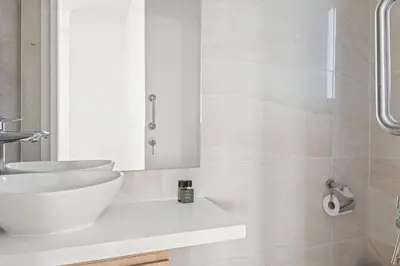 a white bathroom with a sink and a mirror at Serenity Waves Villa 8 in Sophtadhes