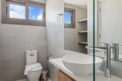 a bathroom with a sink and a toilet at Serenity Waves Villa 8 in Sophtadhes