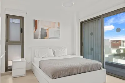 a white bedroom with a bed and a large window at Serenity Waves Villa 8 in Sophtadhes