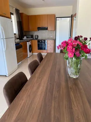 a vase of flowers sitting on a wooden table in a kitchen at A sea breeze house in Voroklini