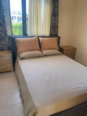 a bed with two pillows in a room with a window at A sea breeze house in Voroklini