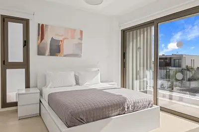 a white bedroom with a bed and a large window at Serenity Waves Villa 11 in Larnaka