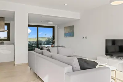 a white living room with a couch and a table at Serenity Waves Villa 11 in Larnaka