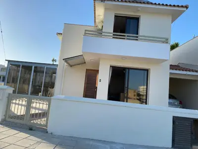 a white house with a balcony at A sea breeze house in Larnaka