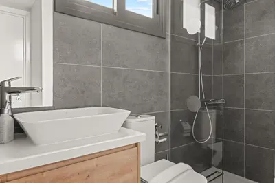 a bathroom with a white sink and a shower at Serenity Waves Villa 20 in Larnaka