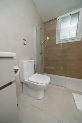 a bathroom with a toilet and a glass shower at 1 bedroom flat in Aglatzia in Aglantzia