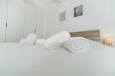 a white bed with towels on top of it at 1 bedroom flat in Aglatzia in Aglantzia