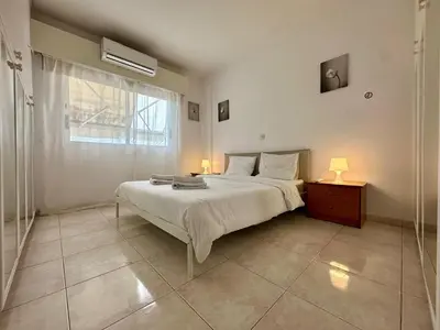 a bedroom with a large bed and a window at 1 bedroom flat 200m from beach in Limassol