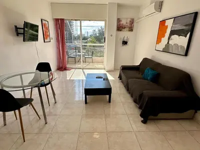 a living room with a couch and a glass table at 1 bedroom flat 200m from beach in Limassol
