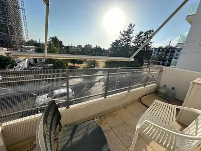 a balcony with two chairs and a view of a city at 1 bedroom flat 200m from beach in Limassol
