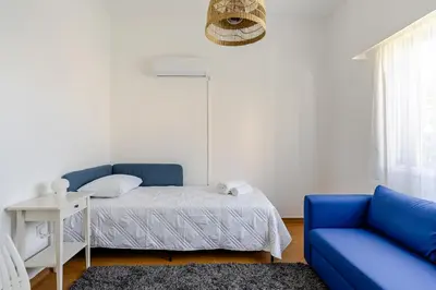 a bedroom with a bed and a blue couch at Central Escape in Limassol