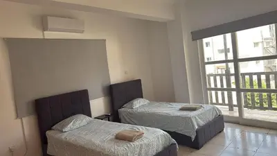 a bedroom with two beds and a large window at Unique City Center Rooms, 150m from Chabad Lubavitch in Larnaka