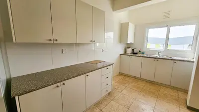 a kitchen with white cabinets and a sink and a window at Unique City Center Rooms, 150m from Chabad Lubavitch in Larnaka