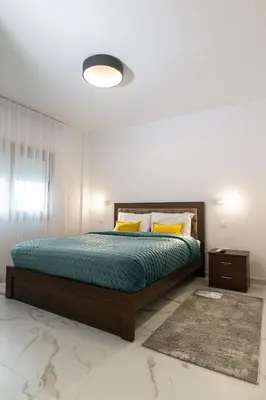 a bedroom with a large bed and yellow pillows at Kozakos Residence in Limassol