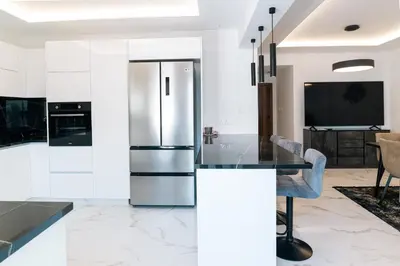 a kitchen with a stainless steel refrigerator and a table at Kozakos Residence in Limassol