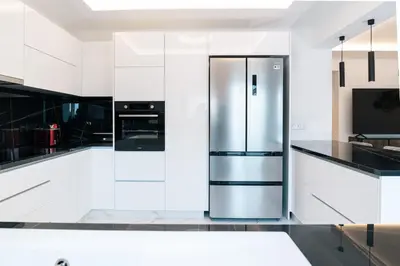 a kitchen with white cabinets and a stainless steel refrigerator at Kozakos Residence in Limassol