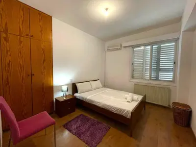 a bedroom with a bed and a chair and a window at Comfort Stay in Nicosia - Aglantzia RIK in Nicosia