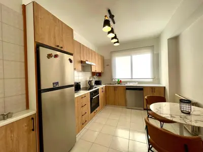 a kitchen with a refrigerator and a table in it at Comfort Stay in Nicosia - Aglantzia RIK in Nicosia