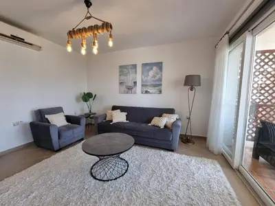 a living room with a blue couch and a table at North Cyprus Thalassa beach resort in Paralimni