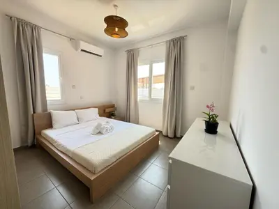a small bedroom with a bed and a window at Wealthystays 3BR Terrace BBQ Villa with pool in Liopetri