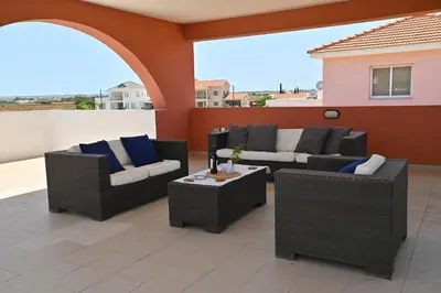 a patio with two couches and a table at Wealthystays 3BR Terrace BBQ Villa with pool in Liopetri