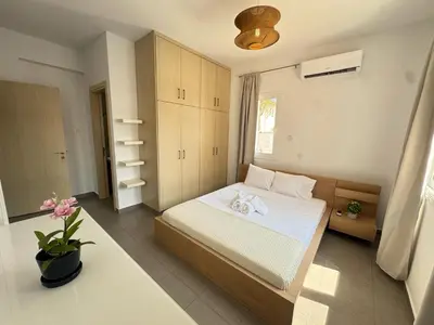 a small bedroom with a bed and a window at Wealthystays 3BR Terrace BBQ Villa with pool in Liopetri