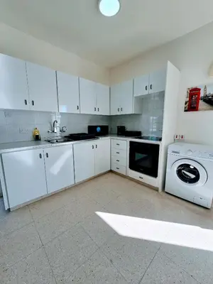 a kitchen with white cabinets and a washing machine at Greco 356 Apartment in Protaras