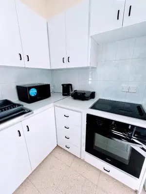 a white kitchen with white cabinets and a microwave at Greco 356 Apartment in Protaras