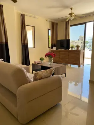 a living room with a couch and a tv at A sea breeze villa in Pyla