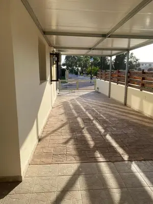 an empty hallway of a building with shadows on the ground at A sea breeze villa in Pyla