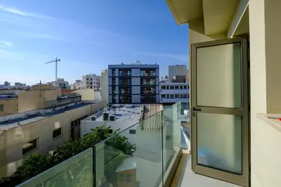 a balcony with a view of a city at Downtown Comfort Apartment in Larnaka