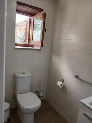 a bathroom with a white toilet and a window at Mountain View Oasis in Skarinou