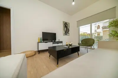 a living room with a bed and a tv at Near City center 1 bedroom flat in Nicosia