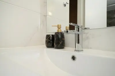 a bathroom sink with a faucet and a mirror at Near City center 1 bedroom flat in Nicosia