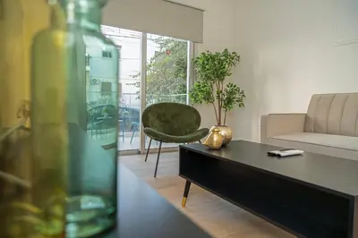 a living room with a table and a green chair at Near City center 1 bedroom flat in Nicosia