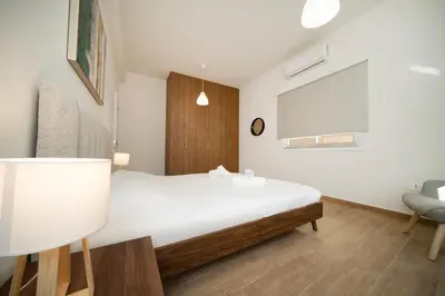 a bedroom with a white bed and a chair at Near City center 1 bedroom flat in Nicosia