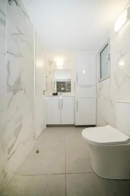 a white bathroom with a toilet and a sink at Near City center 1 bedroom flat in Nicosia