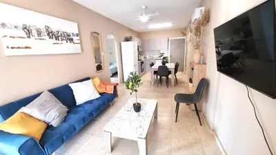 a living room with a blue couch and a table at 5 Min Walk to Beach, Perfect Seaside Escape in Larnaka