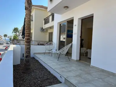 a patio with two chairs and a palm tree on a house at Amour Et Citrons in Protaras