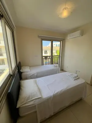 two beds in a room with a window at Amour Et Citrons in Protaras